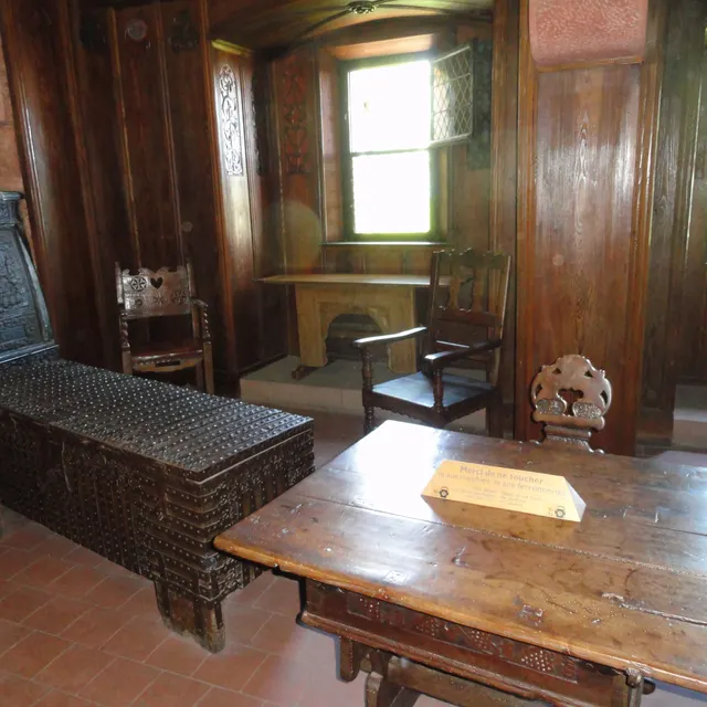 A panelled room with a table and chairs inside Haut-Kœnigsbourg